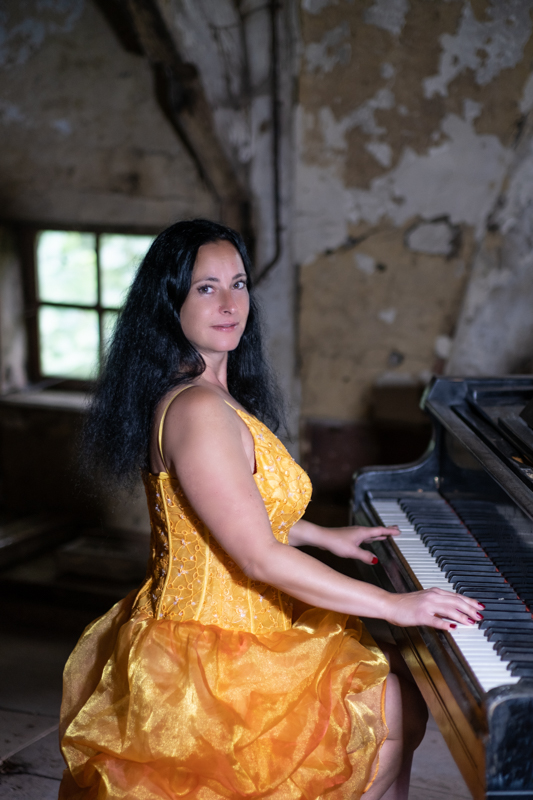 Frau im gelben Kleid Pianospielend