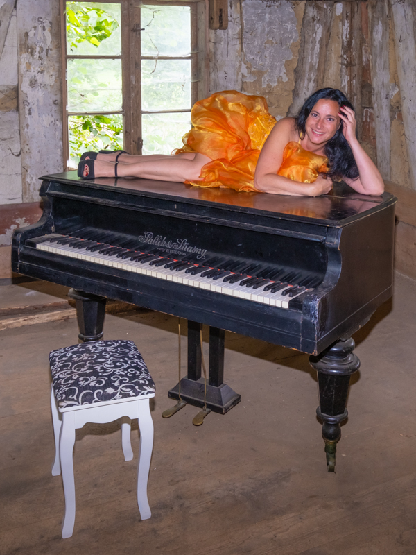 Frau in orangeem Kleid Klavier