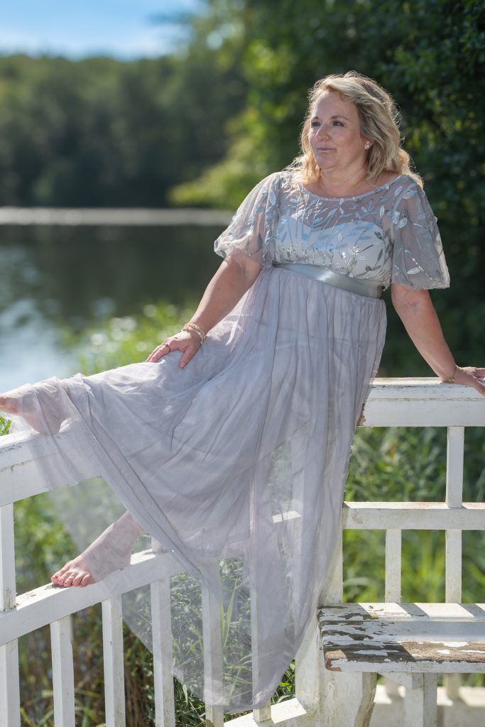 Frau in transparentem Kleid am Wasser