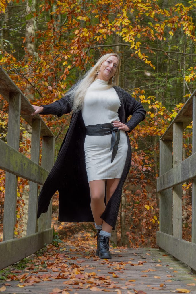 Frau auf Holzbrücke im Herbst