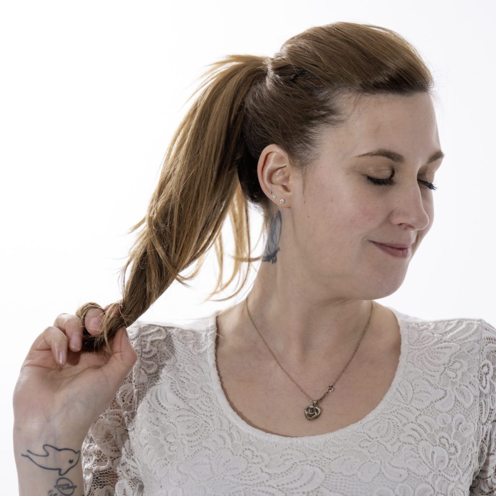 Frau mit Pferdeschwanz lächelnd