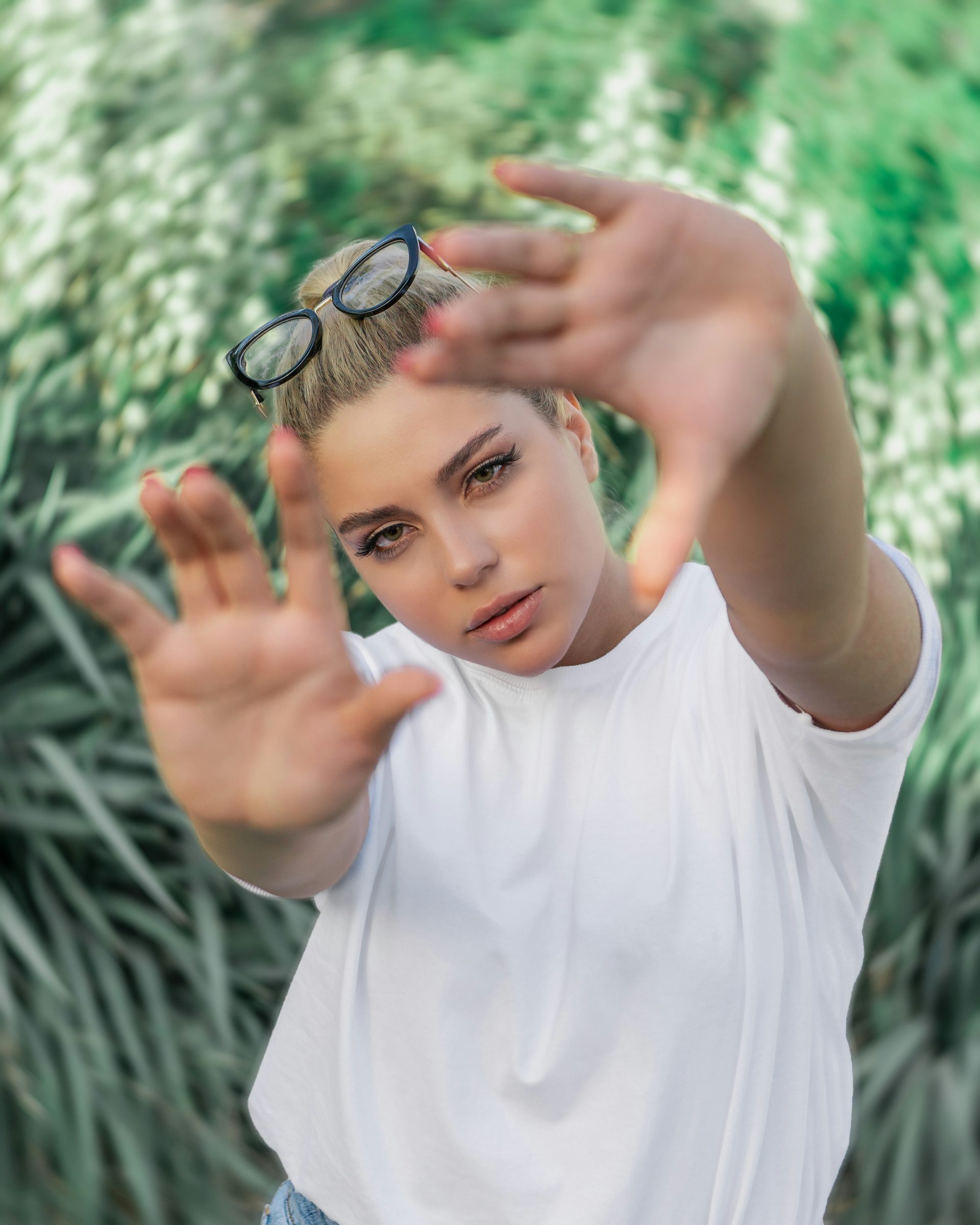 Mädchen im weißen T-Shirt mit Rundhalsausschnitt und schwarzer Brille