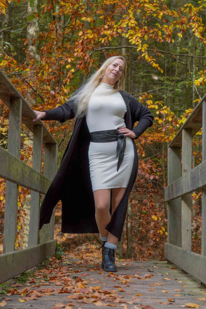 Frau auf Holzbrücke im Herbst